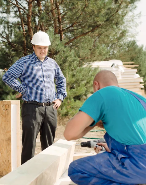 Arquiteto ou capataz assistindo um construtor — Fotografia de Stock