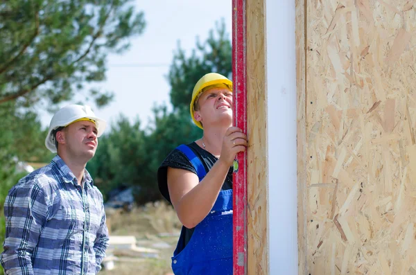 Due costruttori che installano pannelli isolanti — Foto Stock