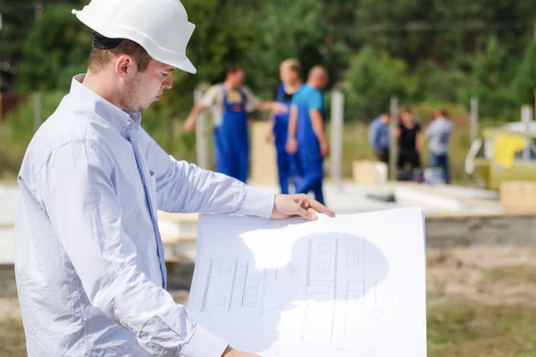 Architect or engineer checking plans on site — Stock Photo, Image