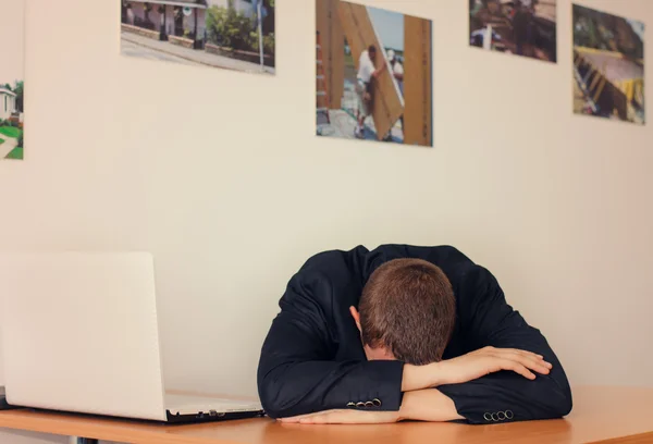 Affärsman med huvudet ner på skrivbord — Stockfoto