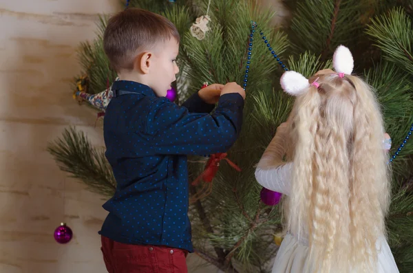 Мальчик и девочка заняты украшением рождественской елки — стоковое фото