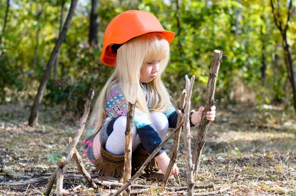 Gadis kecil dengan Helm Bermain dengan Tongkat — Stok Foto