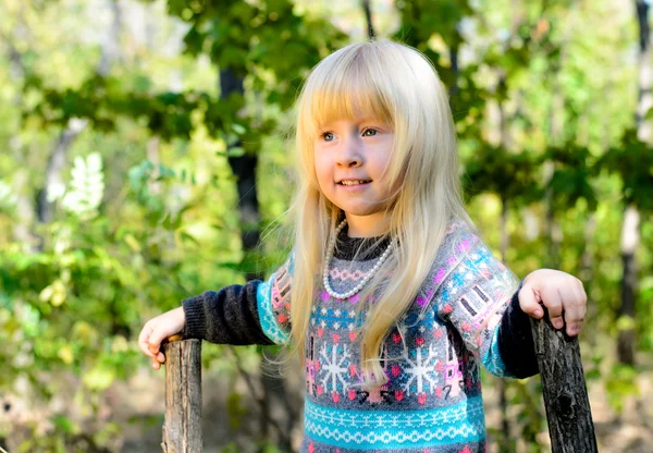 Sonriente niña rubia jugando en el jardín —  Fotos de Stock