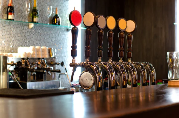 Grifos de cerveza detrás de un mostrador de bar — Foto de Stock