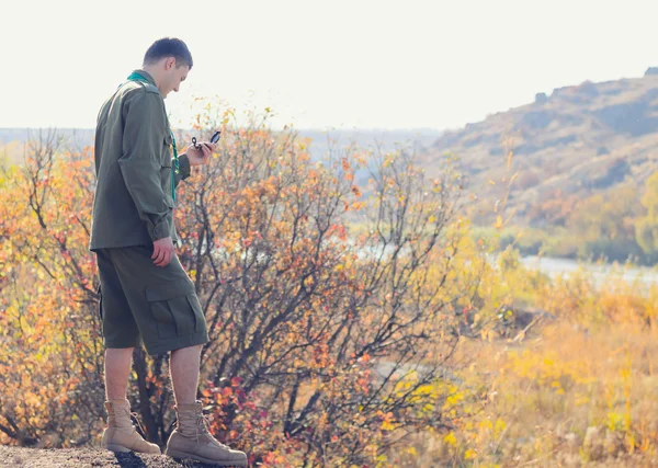 Jonge mannelijke Scout een kompas apparaat navigeren — Stockfoto