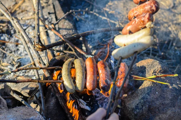 Enchidos e Weiners na vara Cozinhar sobre o fogo — Fotografia de Stock