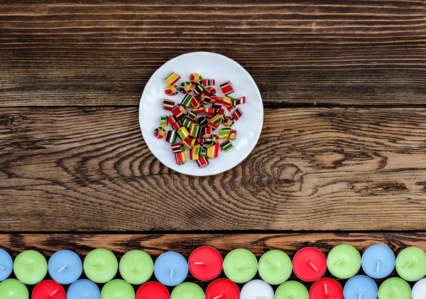 Piatto bianco con caramello e molte candele — Foto Stock