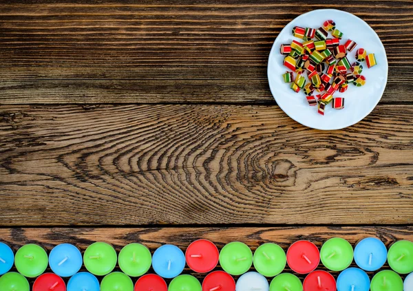 Piatto bianco con caramello e molte candele — Foto Stock