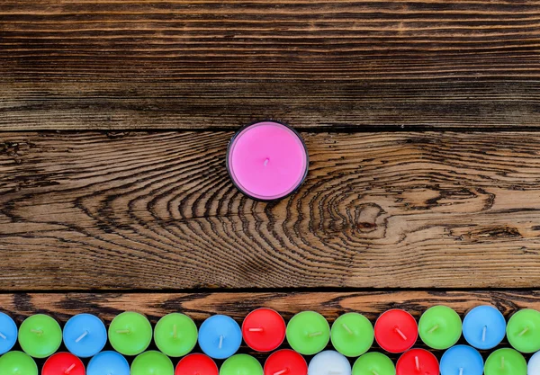Candele di colore diverso su tavolo di legno — Foto Stock