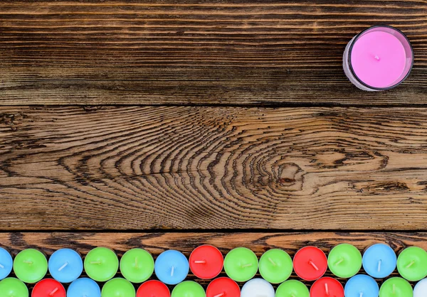 Velas de cores diferentes na mesa de madeira — Fotografia de Stock