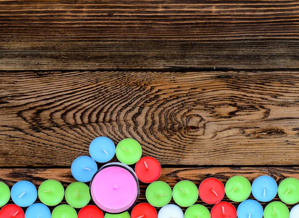 Andere kleur kaarsen op houten achtergrond — Stockfoto