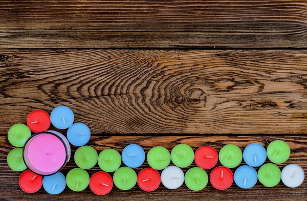 Kerzen in verschiedenen Farben auf Holztisch — Stockfoto