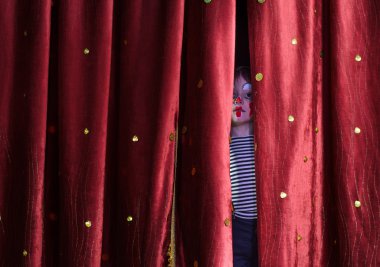 Boy Clown Peering Through Stage Curtains clipart