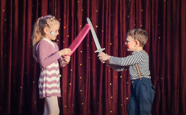 Chico y chica tener fingir espada lucha en el escenario — Foto de Stock