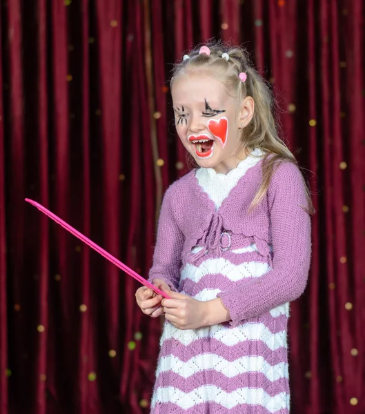 Flicka klädd Clown utgör innehar över storlek kam — Stockfoto