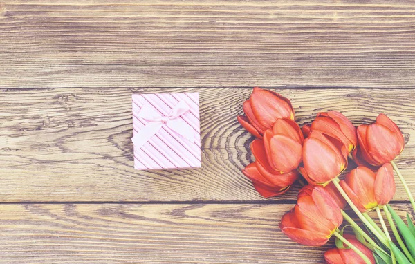 Buquê de tulipas frescas com um presente — Fotografia de Stock