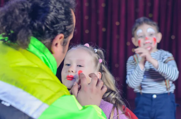 Jong meisje toegepast met Clown make-up door een kunstenaar — Stockfoto