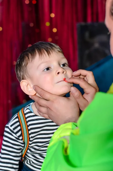 Carino ragazzo applicato con divertente trucco da un artista — Foto Stock