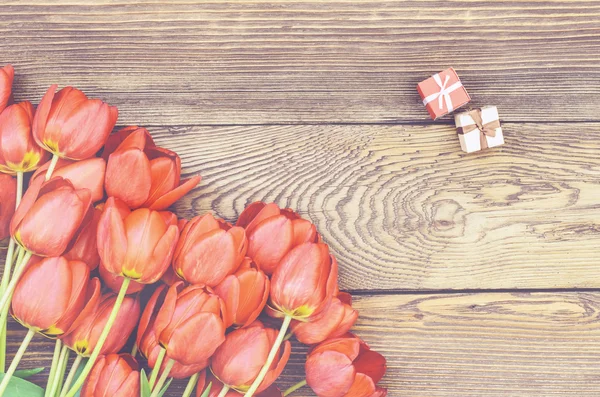 Tulipas na mesa de madeira com pequenas caixas de presente — Fotografia de Stock