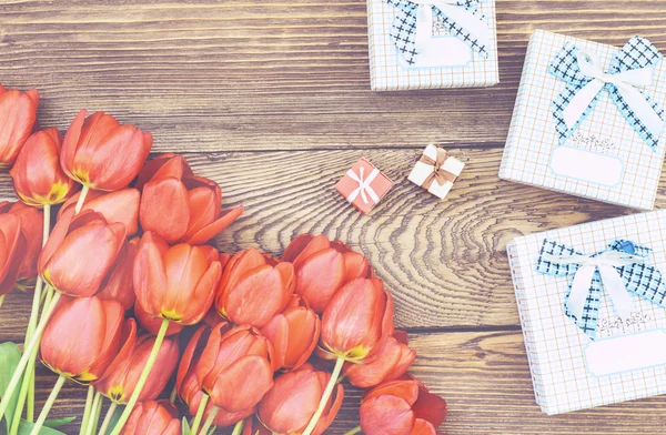 Tulipas na mesa de madeira com pequenas caixas de presente — Fotografia de Stock