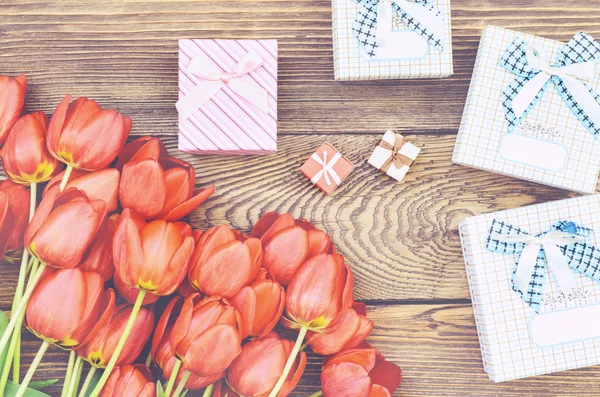 Buquê de tulipas na mesa de madeira com presentes — Fotografia de Stock