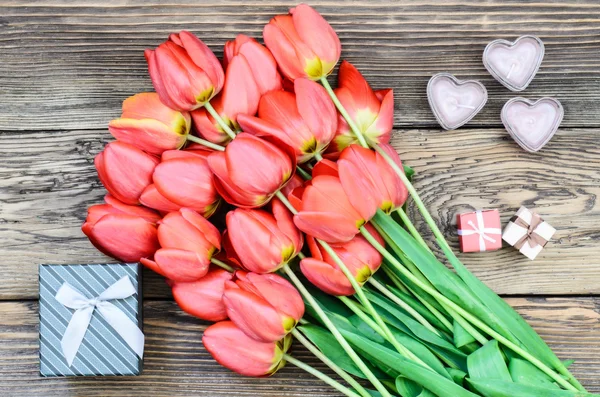 Bouquet of fresh tulips with a gifts — Stock Photo, Image