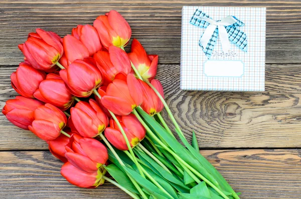 Tulipanes en mesa de madera con pequeñas cajas de regalo —  Fotos de Stock