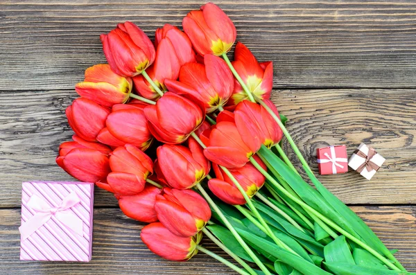 Tulipas na mesa de madeira com pequenas caixas de presente — Fotografia de Stock