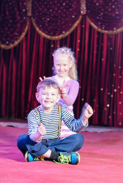 Мальчик и девочка глупо ведут себя на сцене
