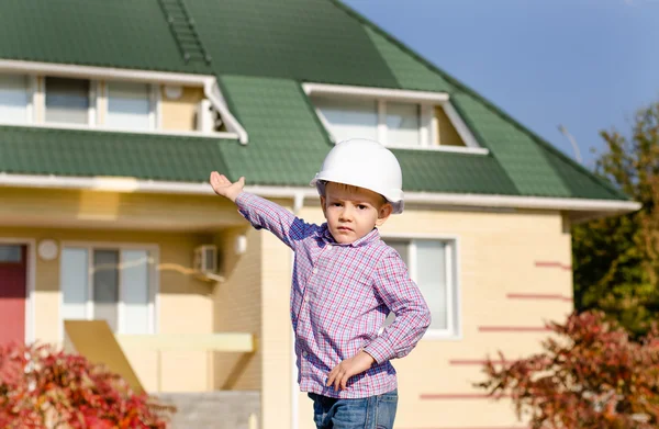 Pojke svårt hatt presentera färdiga hus — Stockfoto
