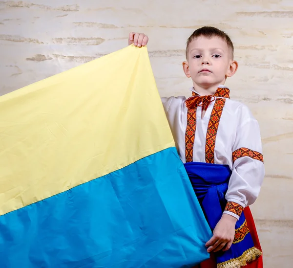 Cute child holding the national flag of Ukraine — Stock Photo, Image