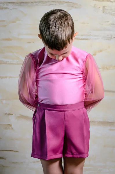 Menino vestindo roupa de dança rosa com cabeça curvada — Fotografia de Stock