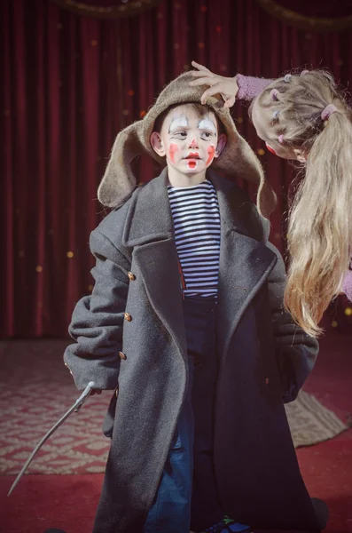 Ragazza regolazione cappello di ragazzo vestito da clown — Foto Stock