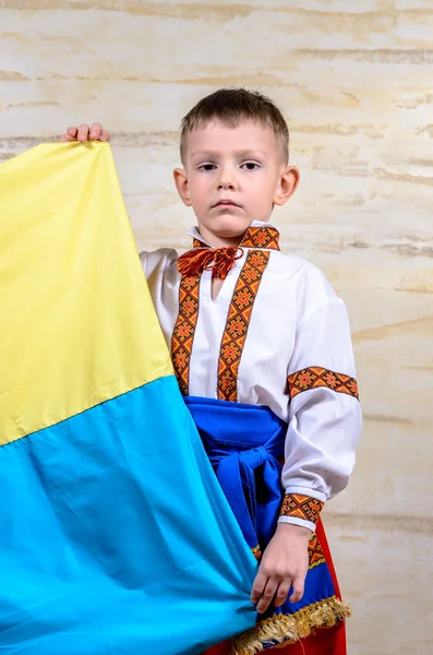 Cute child holding the national flag of Ukraine — Stock Photo, Image