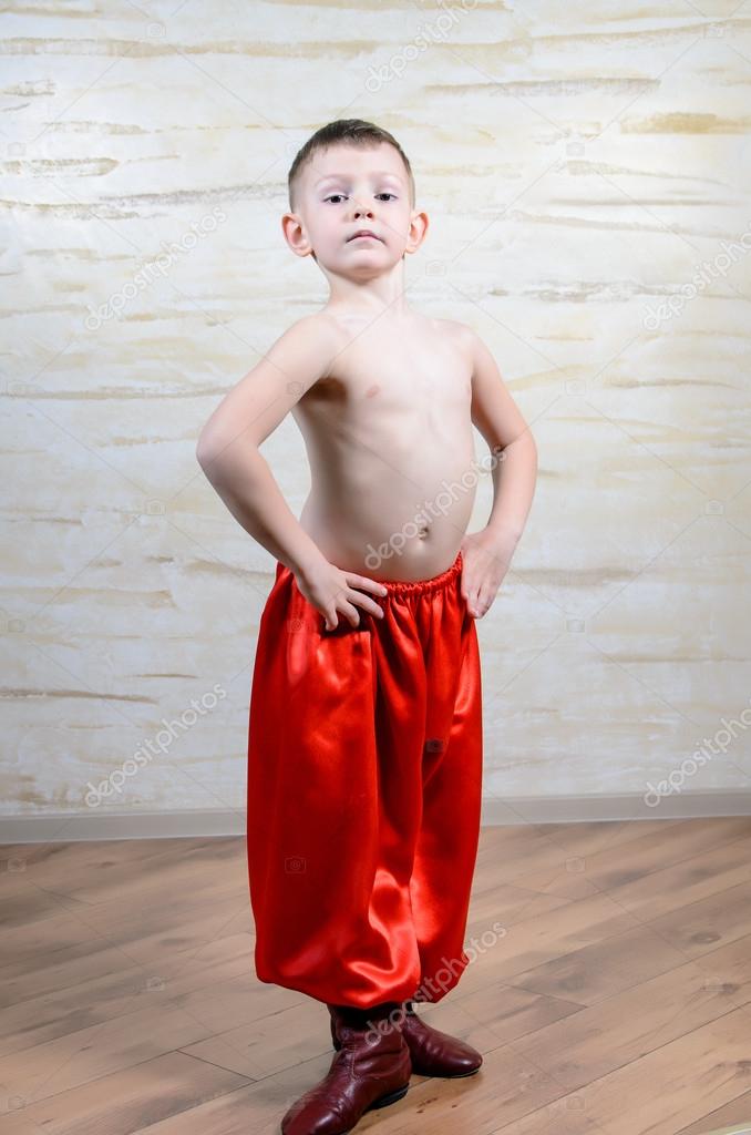 Boy Wearing Traditional Red Dance Pants and Boots