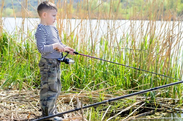 Ernstige jongen aan de rivier houden van hengel — Stockfoto