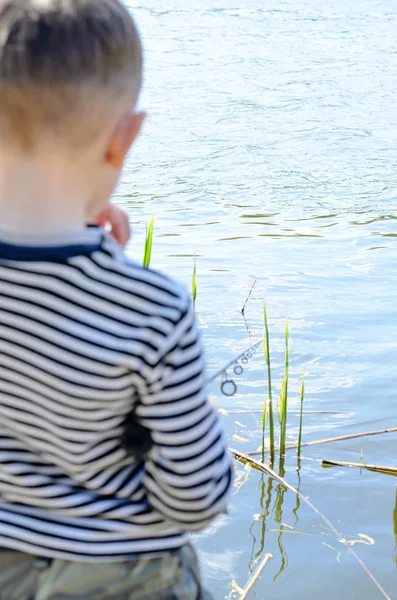 Jonge mannelijke jong geitje, vissen in de rivier alleen — Stockfoto