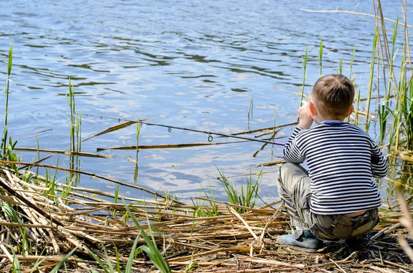 Závažných chlapce, který seděl na Riverside zatímco rybolov — Stock fotografie