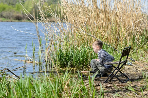 Niño pescando con una caña y carrete —  Fotos de Stock