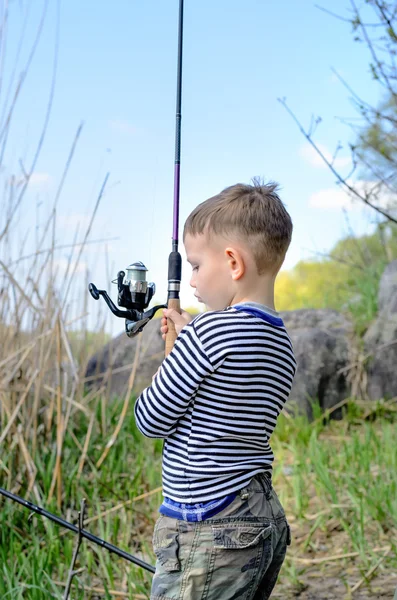 Jonge jongen bedrijf zijn hengel en reel — Stockfoto