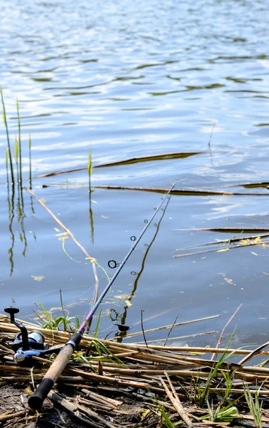 Rybářský prut, ležící na břehu řeky — Stock fotografie