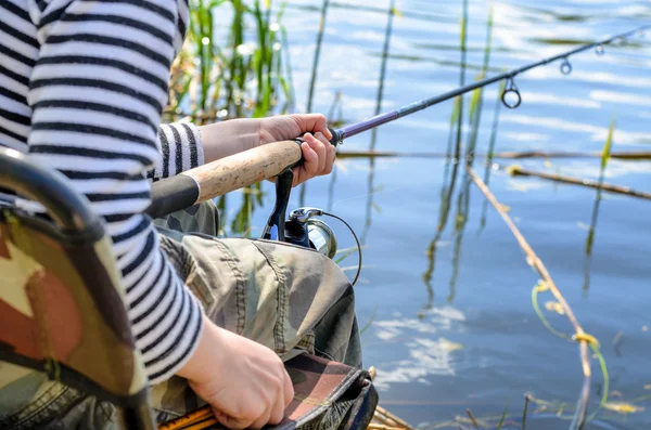 Jonge jongen vergadering visserij op een meer — Stockfoto