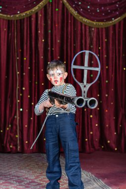 Sahne Alanı'nda büyük tüfek hedefleyen genç erkek palyaço