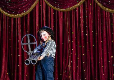 büyük boy tüfek tutarak palyaço gibi giyinmiş genç çocuk