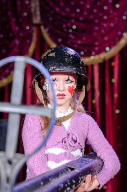 büyük tüfek amaçlayan kask içinde genç kadın palyaço