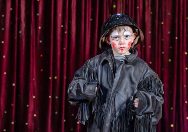 sahnede ayakta palyaço kılığında ciddi çocuk