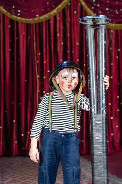 Junger männlicher Clown mit großem Gewehr auf der Bühne — Stockfoto