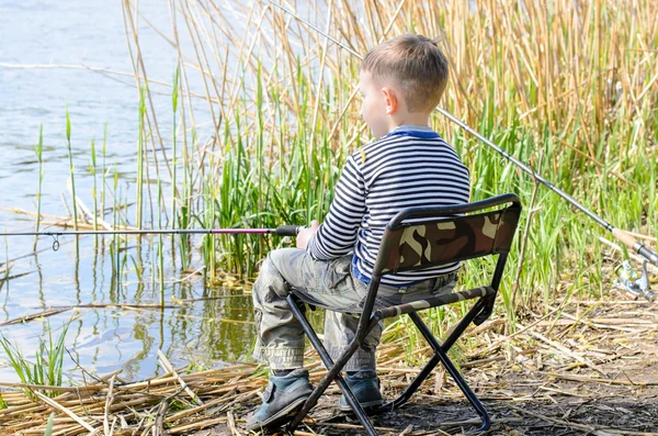 Jongen zittend in stoel en visserij onder de Riet — Stockfoto