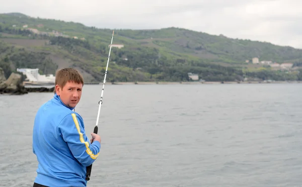 Man standing fishing at the seaside — Stock Photo, Image