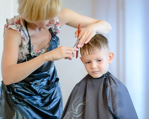 Hairdresser cutting a little boys hair — Stock Photo, Image
